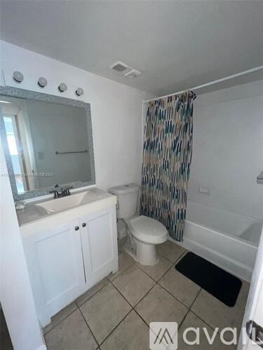 A bathroom with a toilet, sink, and shower.