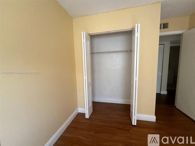 A room with a white door and a wooden floor.