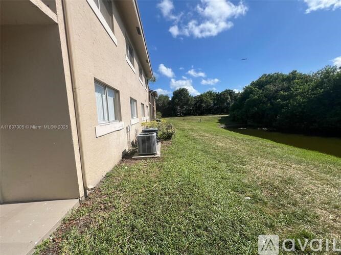A house with a lawn and a body of water in the background.