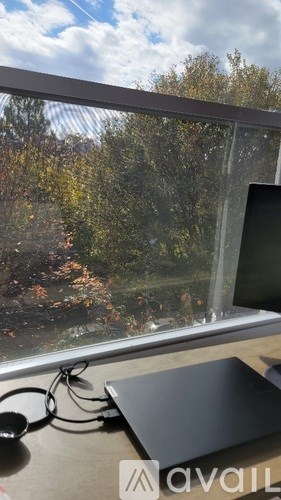 A laptop is open on a desk with a pair of headphones and a microphone in front of it.