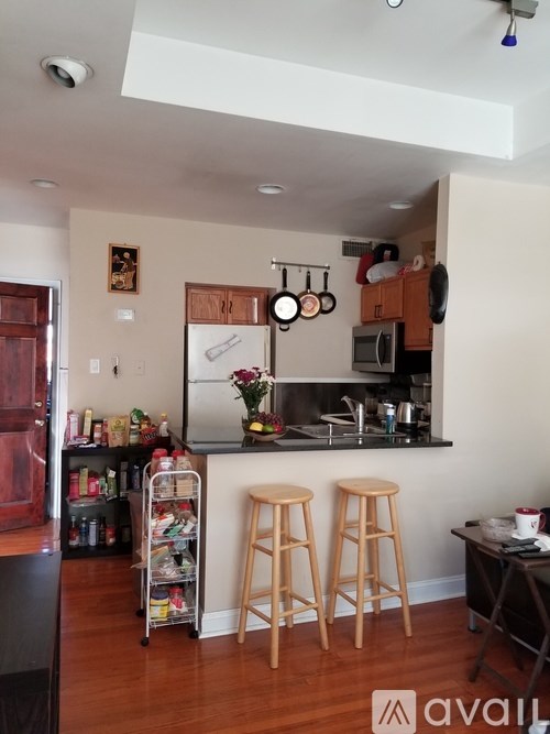 A kitchen with wooden floors and a white ceiling.