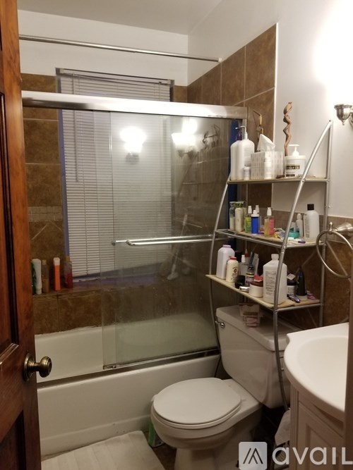 A bathroom with a toilet, sink, and a shower with a glass door.