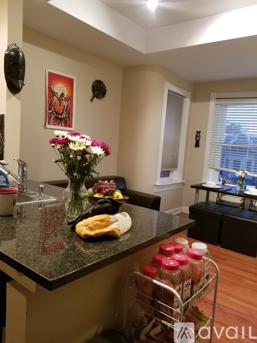 A kitchen with a granite countertop and a vase of flowers on it.
