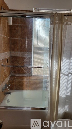 A shower area with a glass door and a glass shelf.