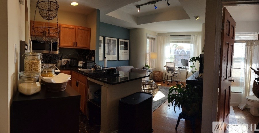 A kitchen with a black counter top and wooden cabinets.