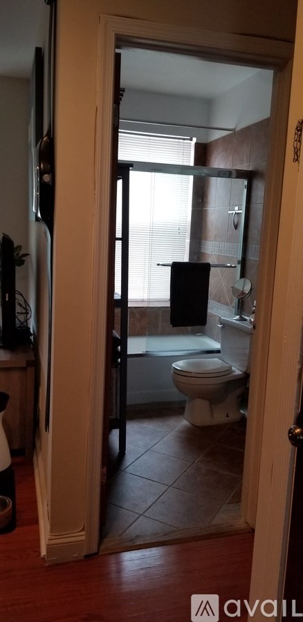 A bathroom with a toilet, sink, and mirror.