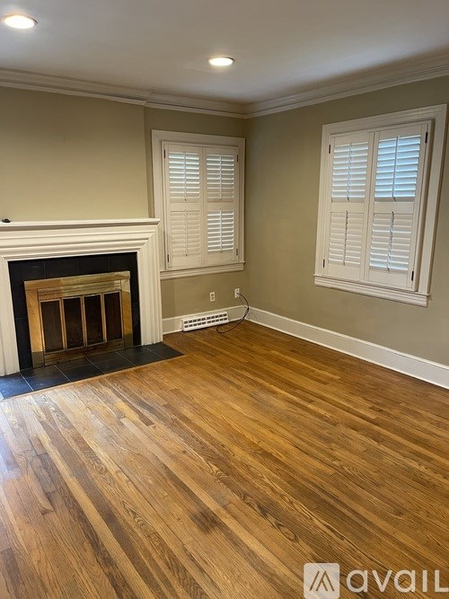 A room with a fireplace and wood flooring.