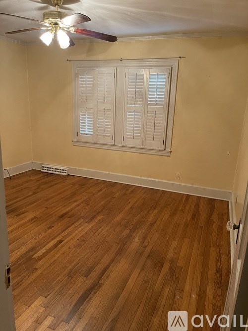 A room with wooden flooring and a ceiling fan.