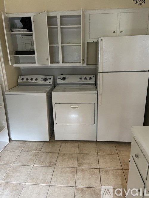 A kitchen with a white fridge, oven, and microwave.