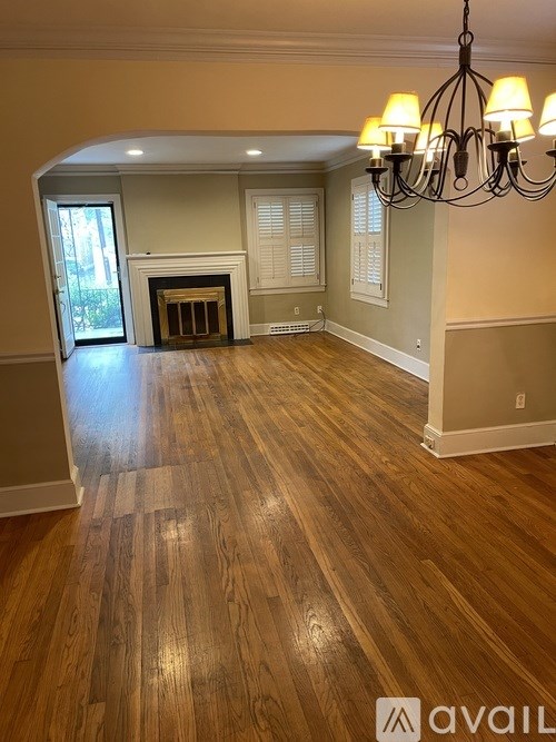 A room with wooden floors and a chandelier.