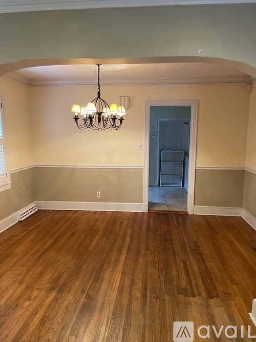 A room with wooden floors and a chandelier.