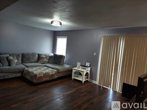 A living room with a grey couch and a wooden floor.