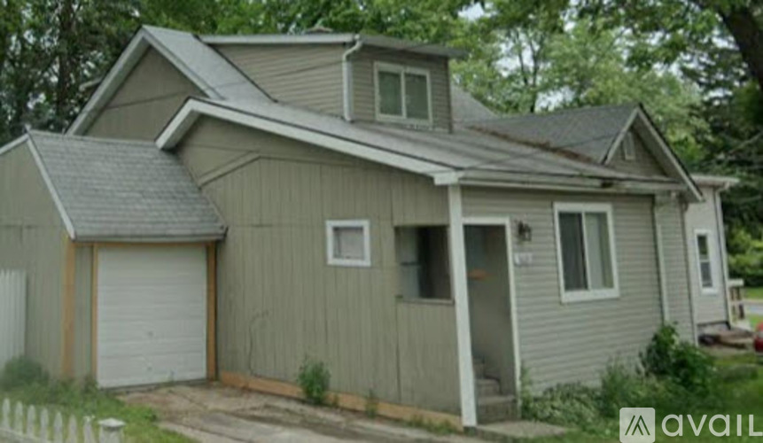 A house with a grey siding and a white garage door.