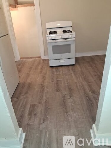 A kitchen with a white stove and green cabinets.