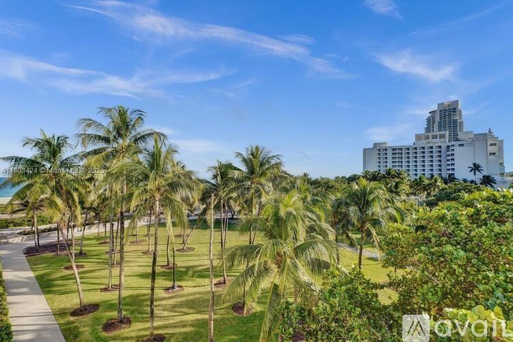 Palm trees line a walkway in front of a building.