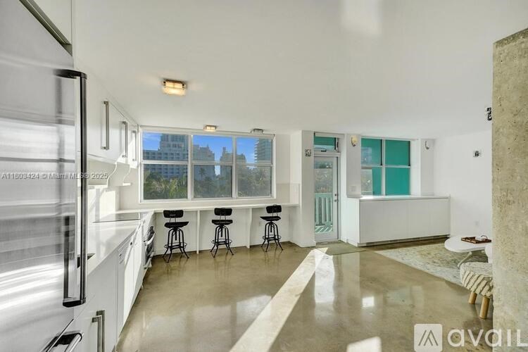 A kitchen with white cabinets and a marble countertop.