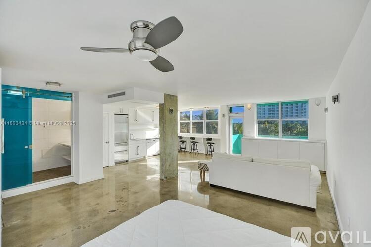 A spacious living room with a white sofa and a ceiling fan.