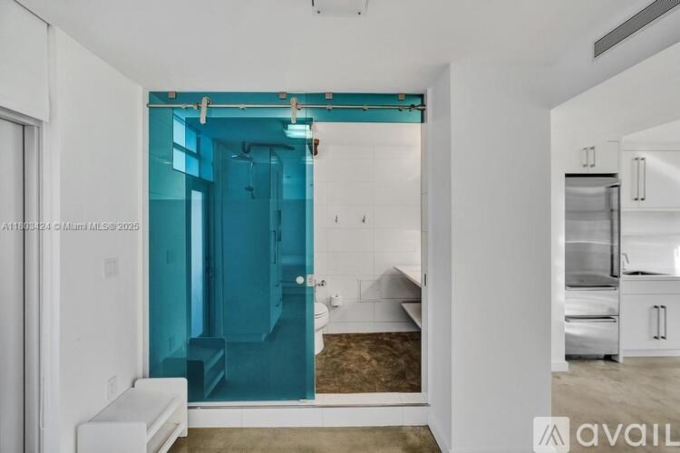 A bathroom with a blue shower and a toilet.