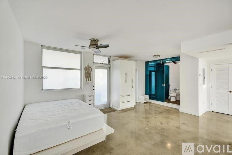 A bedroom with a white bed and a ceiling fan.