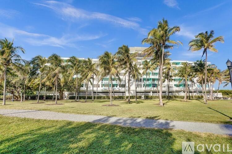 A row of palm trees in front of a building.