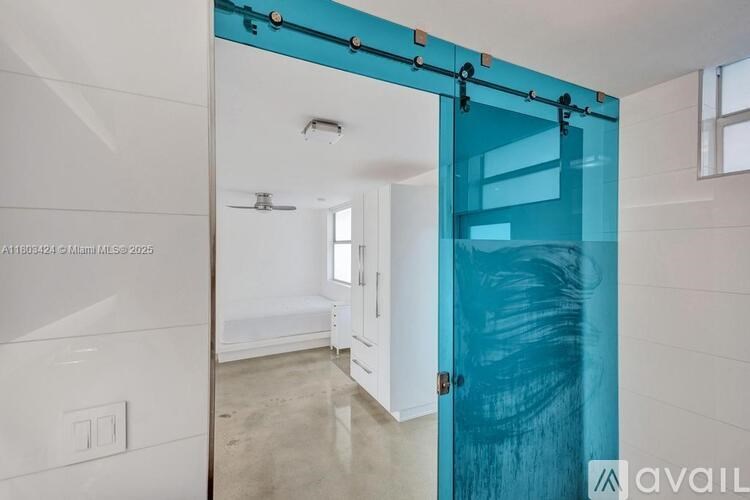 A room with a white wall and a blue door.