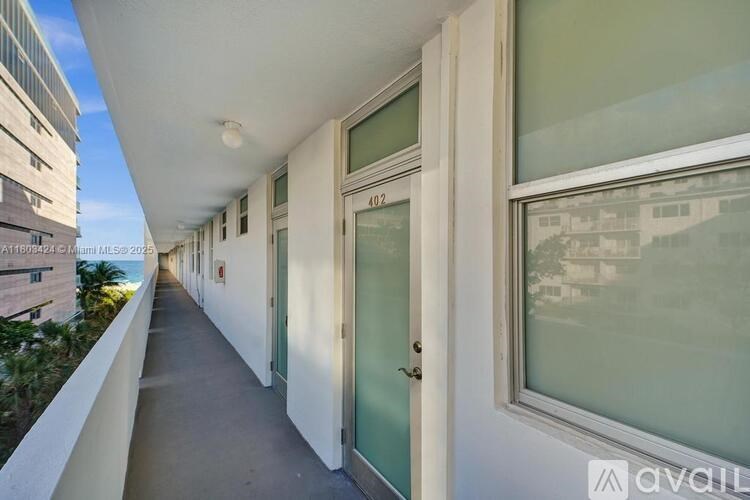 A long, narrow balcony with doors and windows on either side.