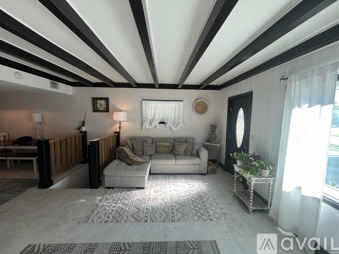A living room with a white couch and a wooden railing.