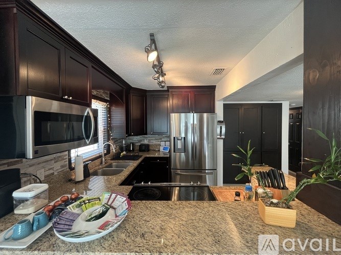 A kitchen with dark wood cabinets and stainless steel appliances.