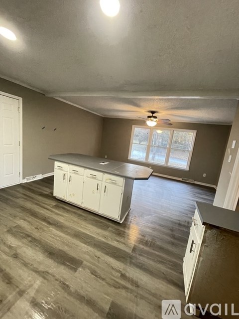 A kitchen with a table and cabinets is available for rent.