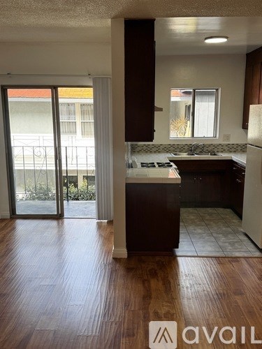 A kitchen with a white fridge and brown cabinets.