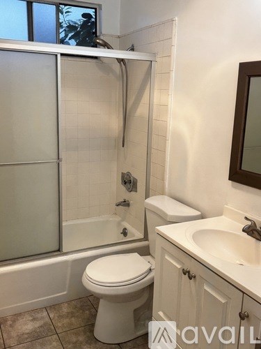 A white toilet sits next to a sink in a bathroom.