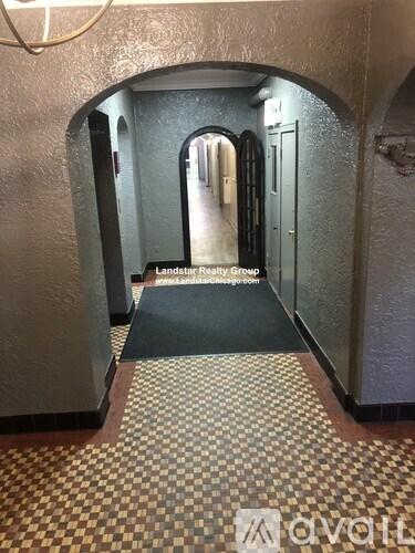 A hallway with a checkered floor and doors on both sides.