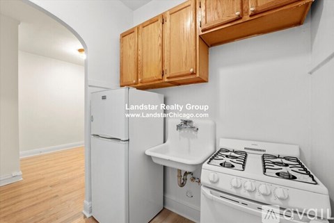 A kitchen with a white stove and wooden cabinets.