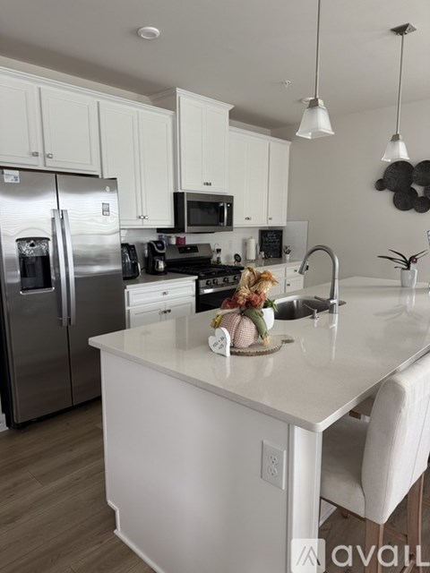 A kitchen with white cabinets and a white island.