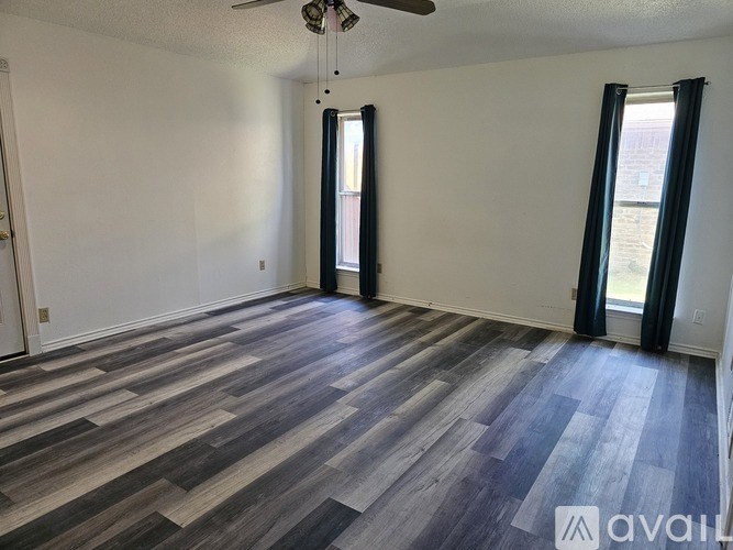 A room with a wooden floor and a ceiling fan.