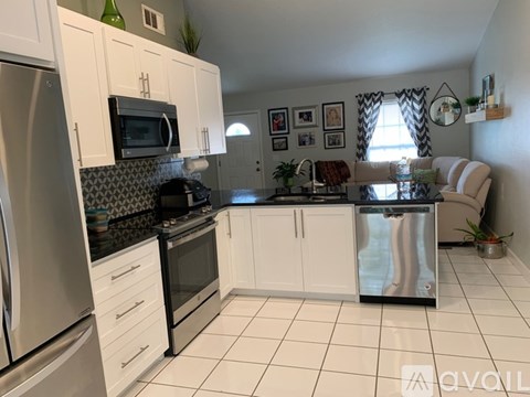 A kitchen with white cabinets and appliances.