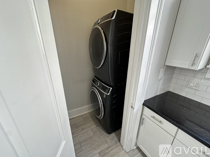 A black washing machine and dryer in a small kitchen.