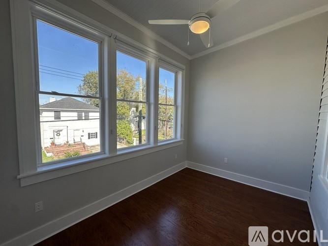 A room with a large window and a fan on the ceiling.