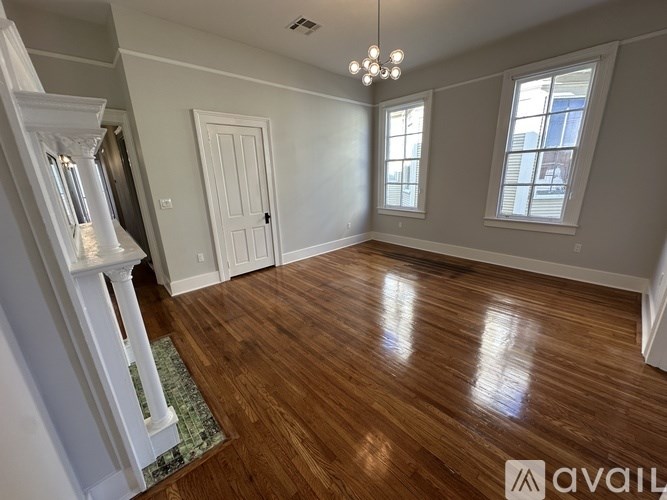 A room with wooden floors and a chandelier.