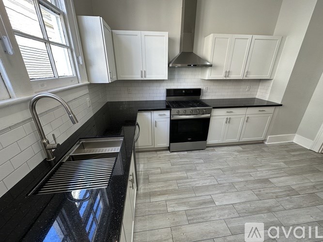 A kitchen with black countertops and white cabinets.