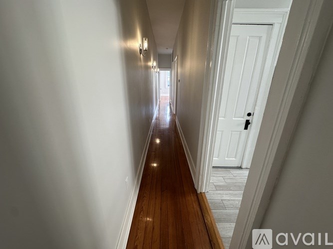 A long hallway with a white door at the end.
