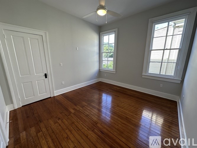 A room with wooden flooring and a window with blinds.