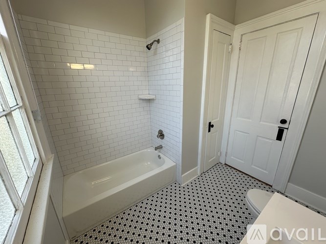 A white bathroom with a black and white floor.