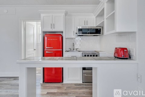 A kitchen with a red fridge and toaster.