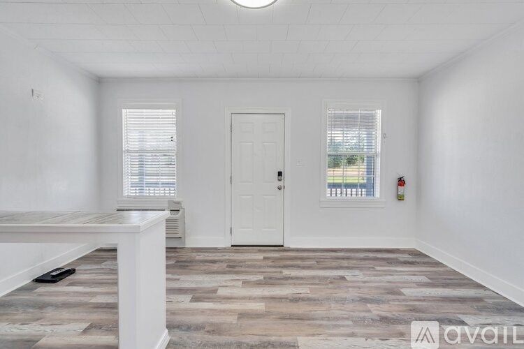 A room with a wooden floor and a white door.