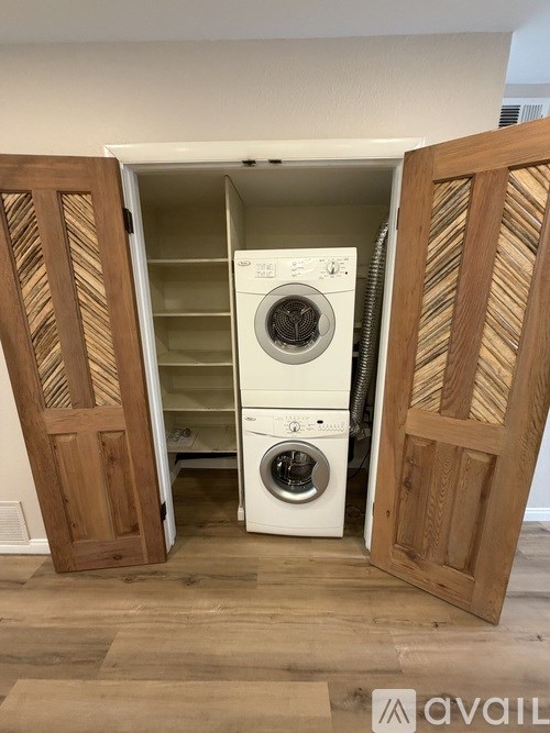 A washing machine is installed in a wooden door.