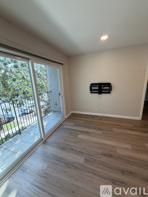 A room with a sliding glass door leading to a balcony.