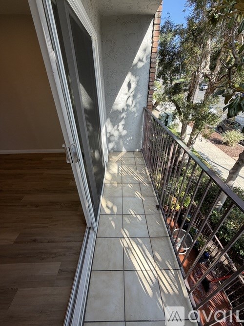A balcony with a railing and a view of trees.