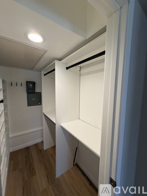 A white shelving unit in a room with a light on the ceiling.