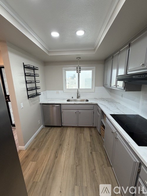 A kitchen with wooden floors and white walls.